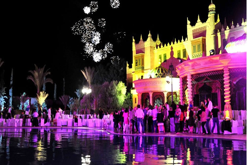 Fireworks above the illuminated Chez Ali venue and visitors at night