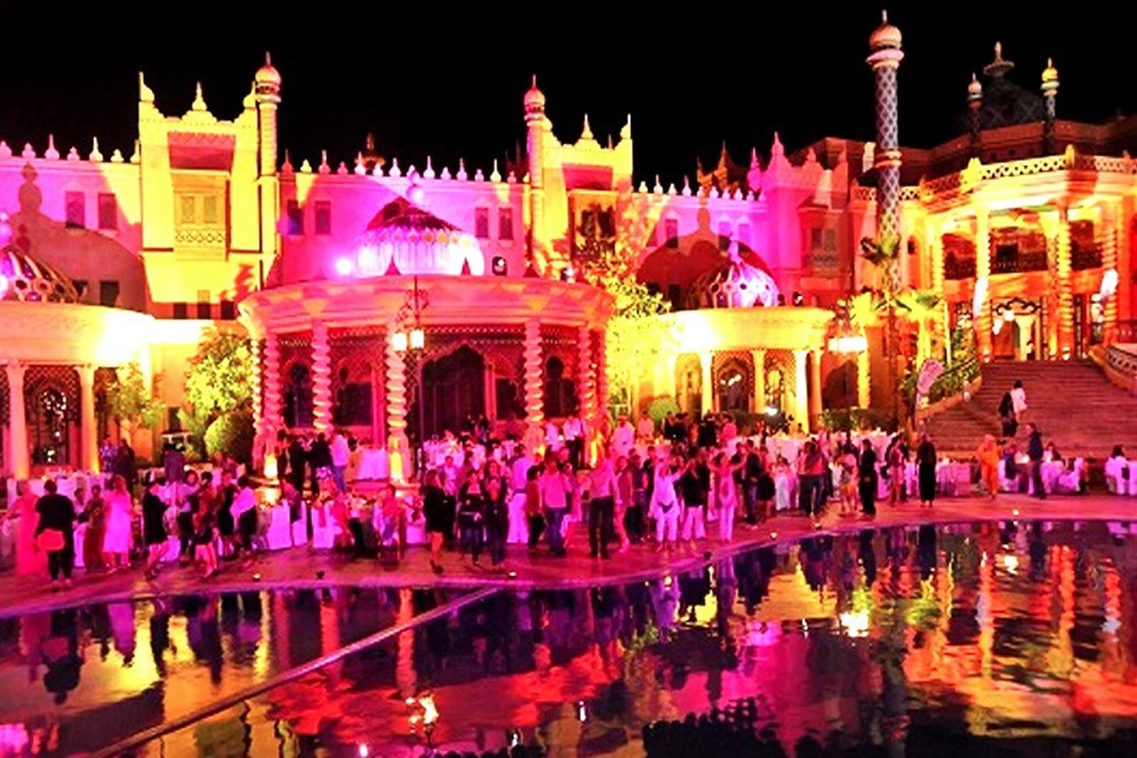 Edificios iluminados de Chez Ali reflejados en la piscina por la noche