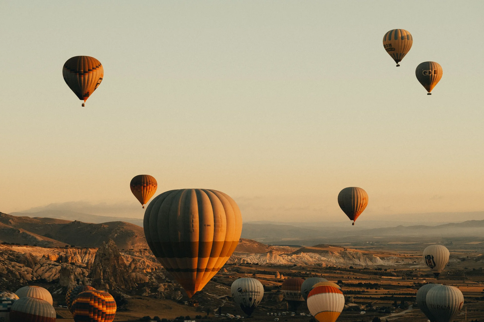 Hot air balloons above a desert landscape at sunrise