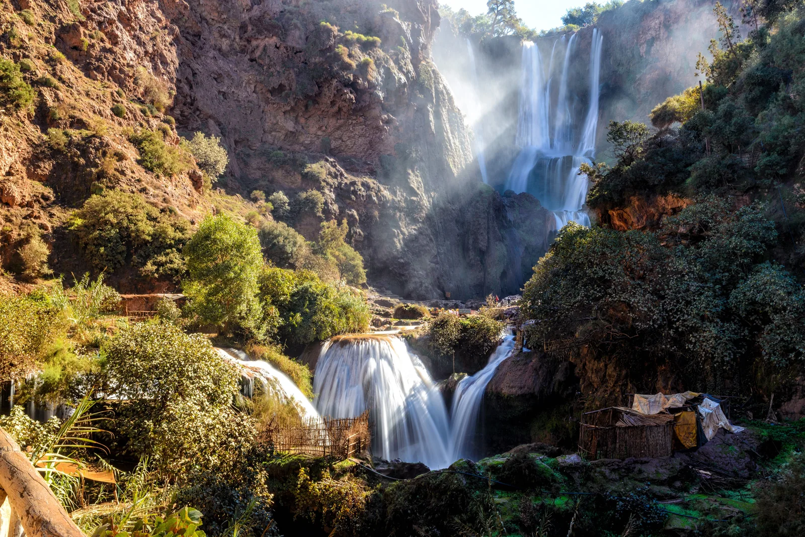 Ouzoud Waterfalls and lower cascades surrounded by cliffs and green vegetation