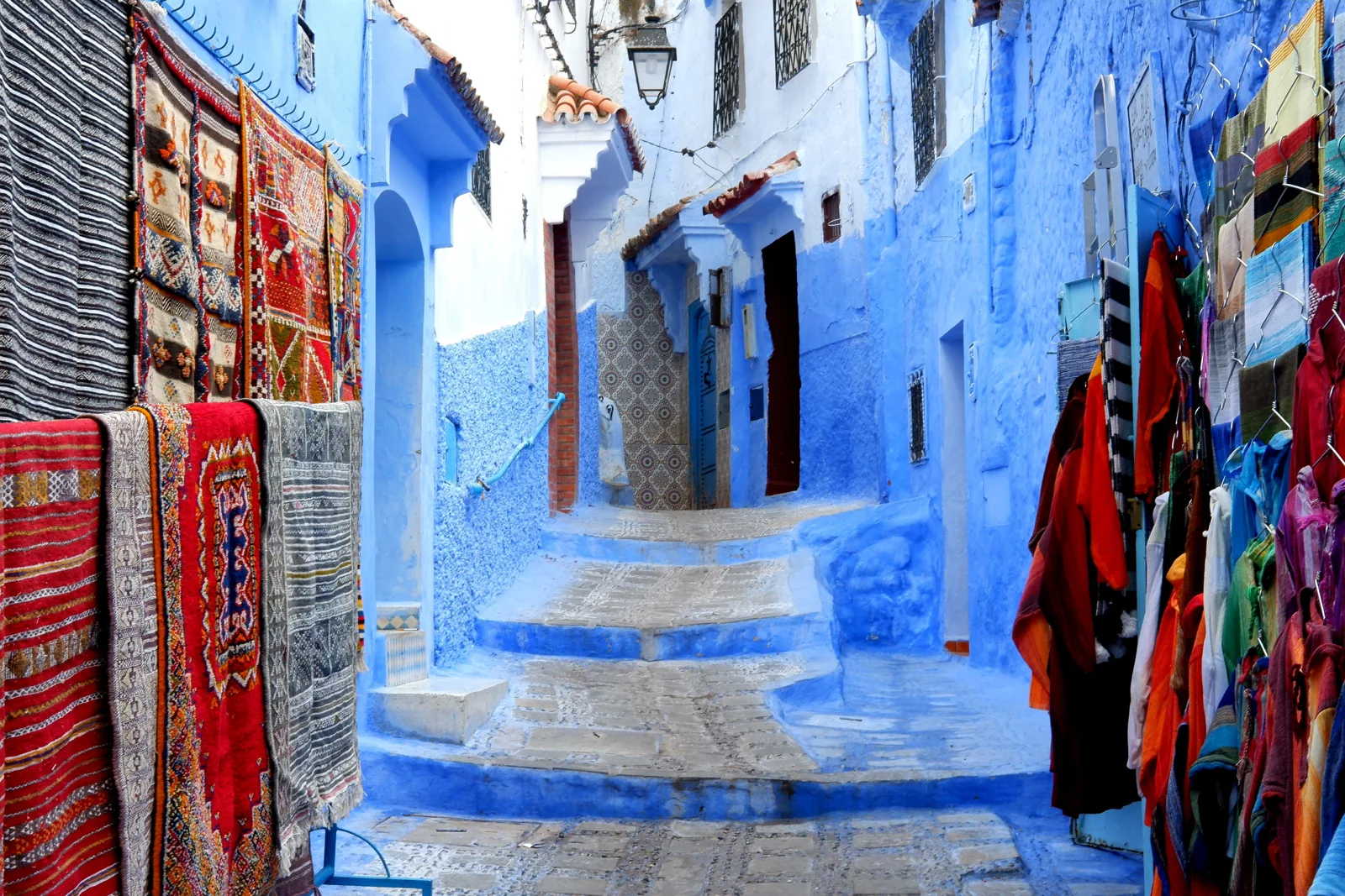 Blue steps and colorful shops in a Chefchaouen medina street