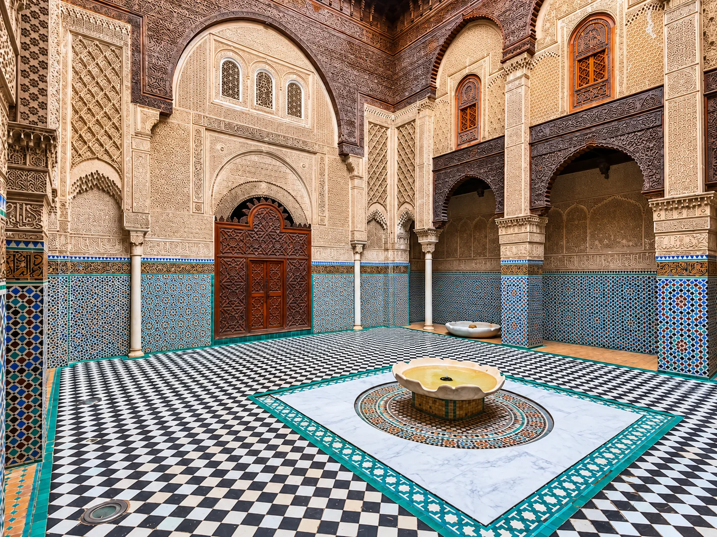 Ornate arches and mosaic tiles surrounding a courtyard fountain in Morocco